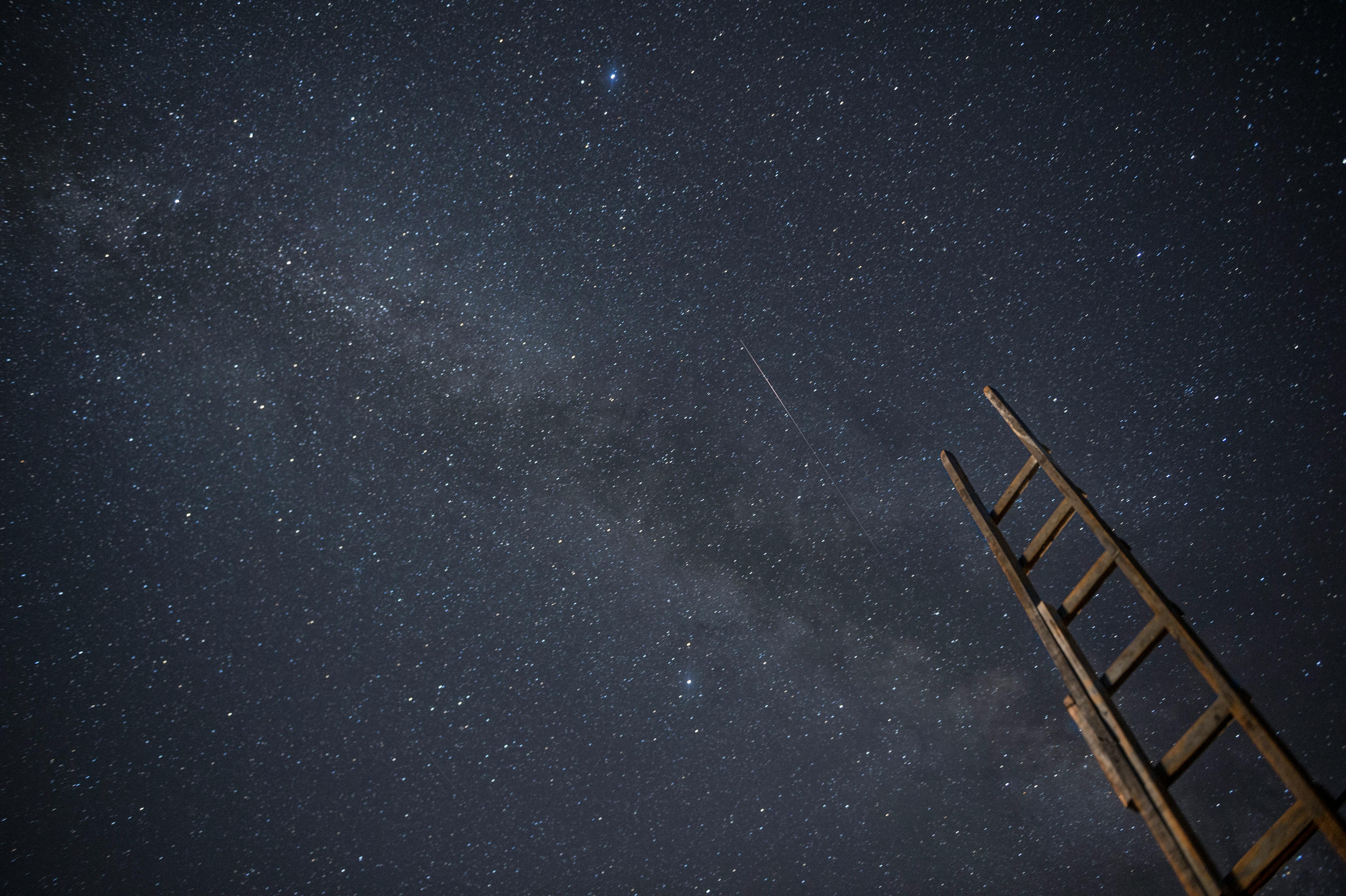 A wooden ladder under a star-filled night sky, ideal for astronomy enthusiasts.