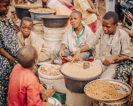 Children interact at a vibrant street market in Zaria City, capturing cultural life.